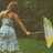 A pixelated image of a woman in a light blue dress holding a colorful umbrella on a green background with blue text.