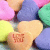 A heart-shaped icon with a pixelated 'LOVE' text in red on the left and pink 'LOVE YOU' text with blue dot on the right, surrounded by pastel-colored hearts.