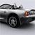 A silver convertible car with a black soft top is shown in profile view, featuring a visible headlight and wheel.