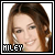 Pixelated portrait of a person with light brown hair and fair skin, smiling slightly against a white background.