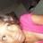Pixelated image of a person with dark hair wearing a pink sleeveless top, light skin, and a blurred background.