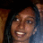 Pixelated close-up of a person with dark hair, light skin tone, and visible teeth in a smiling expression against a blurred background.