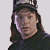 A person wearing a dark cap with white text and black shirt appears in two sequential poses against a plain background.