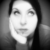 Black-and-white pixelated portrait of a person with dark hair, neutral expression, and visible facial features including eyes, nose, mouth, and chin.