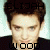 Pixelated portrait of a person with dark hair and light skin, wearing dark clothing, with text overlays above and below the head.
