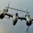 Three pixelated aircraft with dark wings and light bodies fly in a diagonal formation against a pale blue background.