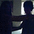 Silhouetted figures in a dimly lit room with two windows, one figure extending an arm toward the other.