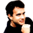 Static pixelated icon of a person with dark hair wearing a black top, holding a white object against a transparent background.