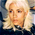Static 50x50 pixel icon showing a close-up of a person with light-colored hair and dark clothing against a blurred background.