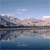 Pixelated landscape with blue sky, clouds, and water reflecting distant landmasses.