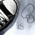 Pixelated black-and-white icon shows a partial face with dark hair and a light background, featuring a small heart symbol and curved line detail.