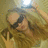 Pixelated image of a person with dark hair wearing a light-colored top, making a hand gesture with the index finger raised against a blurred background.