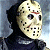 Pixelated static image of a person wearing a white hockey mask with black eye holes and red smudges, dark clothing, and a blurred background.