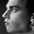 Monochrome pixelated profile of a human face in rightward orientation with visible nose, eye, and cheek, set against dark background.