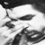 Black-and-white pixelated image of a stylized figure with dark hair and facial features against a light background.