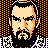 Pixelated 48x48 buddy icon depicting a stylized male face with dark hair, beard, and mustache against an orange-and-black dotted background.