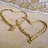 A pixelated heart-shaped icon with a golden-brown outline on a beige background, featuring a small bow detail on the left side.