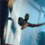Pixelated static image of a martial arts figure in mid-kick against a blue and white background with visible dithering and anti-aliasing artifacts.