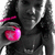 Pixelated static image of a person in dark clothing holding a bright pink heart-shaped object with visible pixelation and grayscale tones.