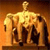 Golden statue of a standing figure with outstretched arms, set against a gradient background transitioning from orange to brown.