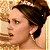 Pixelated image of a woman with brown hair in an updo wearing earrings and a tiara, next to green text reading "Original Icons .com" on dark background.