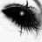Black-and-white eye with heavy eyeliner and mascara, partially obscured by blurred motion effect.