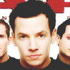 Three men in black shirts appear in a cropped close-up, with a red and white background partially visible behind them.