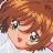 Pixelated close-up of a character with brown hair, green eyes, and a red heart-shaped mark on the cheek, set against a light background.