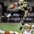 Animated sequence showing a football player in camouflage uniform running with ball, viewed from side on grass field background.
