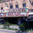 Pixelated static image of a building facade with multiple windows and a dark lower section, likely a theater structure.