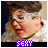 Pixelated image of a person with brown hair and white fur collar, showing four variations of text below the face.