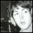 Static grayscale pixelated image of a person's face with dark hair, visible eye, nose, mouth, and partial shoulder in low-resolution format.