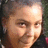 Pixelated close-up of a person's face with light skin tone, brown hair visible on the left side, and dark clothing in the lower right corner.