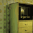 Pixelated image showing a green cabinet with yellow drawers and a black screen displaying a small light, next to large text reading THE EARLY NOVEMBER on a pale background.