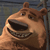 Pixelated cartoon bear with brown fur, wide open mouth showing teeth, and a tilted head against a blurred background.