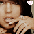 A person with dark hair and light skin holds a hand near their face, wearing rings on multiple fingers; pink heart icons appear in different corners across frames.
