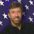Pixelated portrait of a man with short brown hair and light skin, wearing dark clothing against a purple background with white stars.