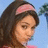 A pixelated image of a person with long dark hair and a pink headband, next to green digital text on a dark blue background.