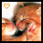 A pixelated cat with orange and white fur, dark eyes, and a black nose rests its head on a surface under bright lighting.