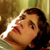 Static pixelated image of a person's face in profile with brown hair and warm lighting against a blurred background.