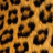 A static image of a repeating pattern featuring irregular dark brown and black shapes on an orange-brown background.