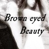 Black-and-white image of a person with long hair wearing a white top, overlaid with text reading "Brown eyed Beauty" in a cursive font.