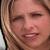 Pixelated close-up of a person's face with light brown hair, closed eyes, and visible mouth area.