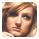 Pixelated close-up of a person's face with light brown hair, neutral expression, and visible eyes nose mouth against blurred background.