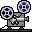 Two pixel-art film projectors with blue-and-black reels, gray bodies, white accents, and red indicator lights on a light gray background.