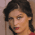 Pixelated close-up of a person with dark hair styled in a side part, wearing red lipstick and a red garment, against a muted brown background.