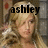 A four- shows a blonde woman with wavy hair in a room with brick walls and red circular decorations; text above the top-left and top-right reads 'ashley' and 'tisdale' respectively, while the bottom-left displays a black heart symbol on her head