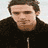 Static 48x48 pixel buddy icon showing a man with short brown hair wearing a black zip-up jacket against a light background.