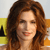 A pixelated close-up of a person with long brown hair against a yellow and orange background.