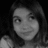 Black-and-white pixelated image of a person with shoulder-length hair, neutral expression, and light-colored clothing against dark background.